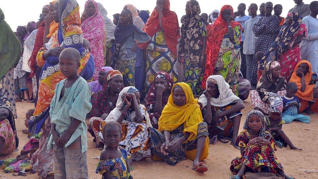 Women and children fleeing from Boko Haram attacks sit at Kabalewa Refugees Camp in Niger on 13 March 2015