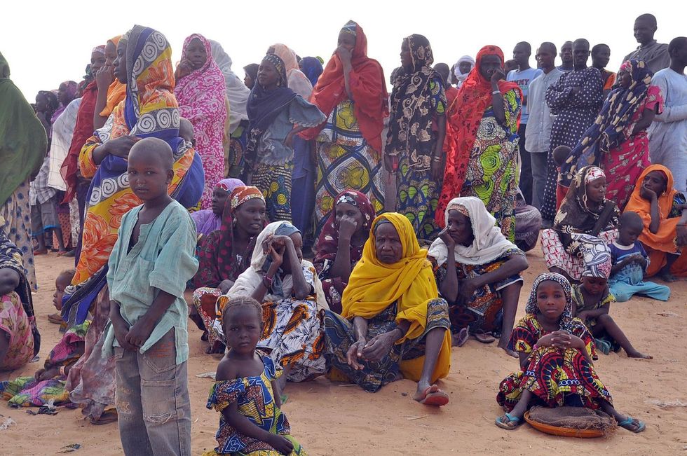 Women and children fleeing from Boko Haram attacks sit at Kabalewa Refugees Camp in Niger on 13 March 2015