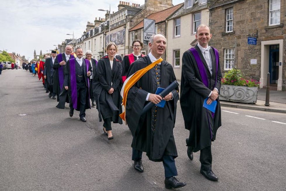 Writer Armando Iannucci walks with other graduates in a procession through St Andrews after receiving an honorary degree in the Fife town