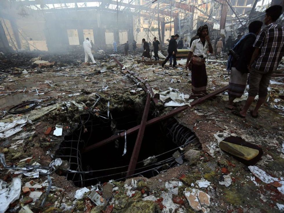 Yemenis inspect the site of Saudi-led airstrikes that hit a funeral ceremony in Sana\u00eda